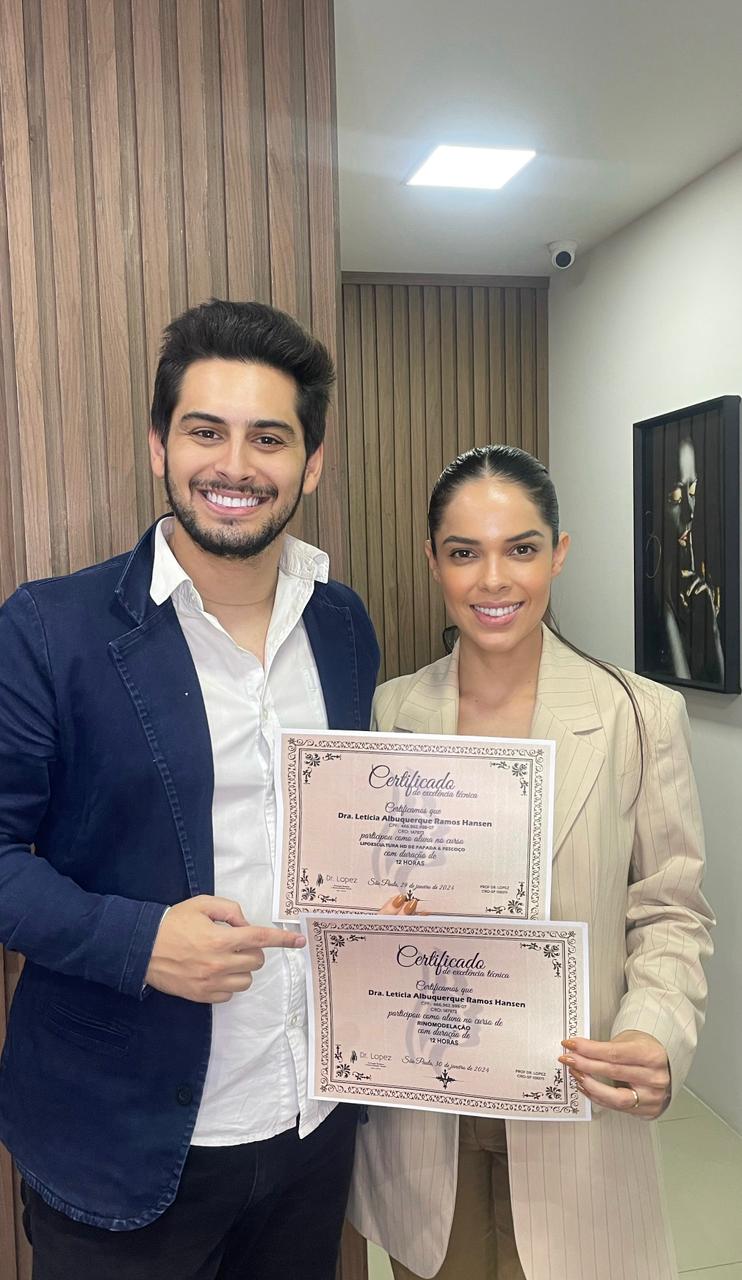 Dr. Lopez ao lado de aluna com certificados da formação presencial
