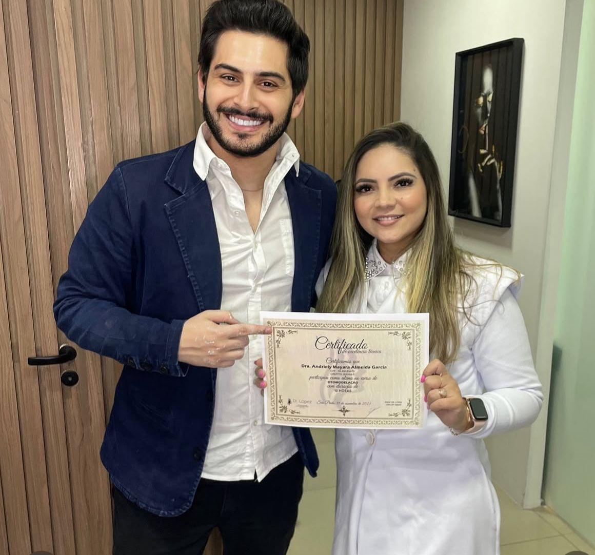 Dr. Lopez ao lado de aluna segurando certificado de otomodelação