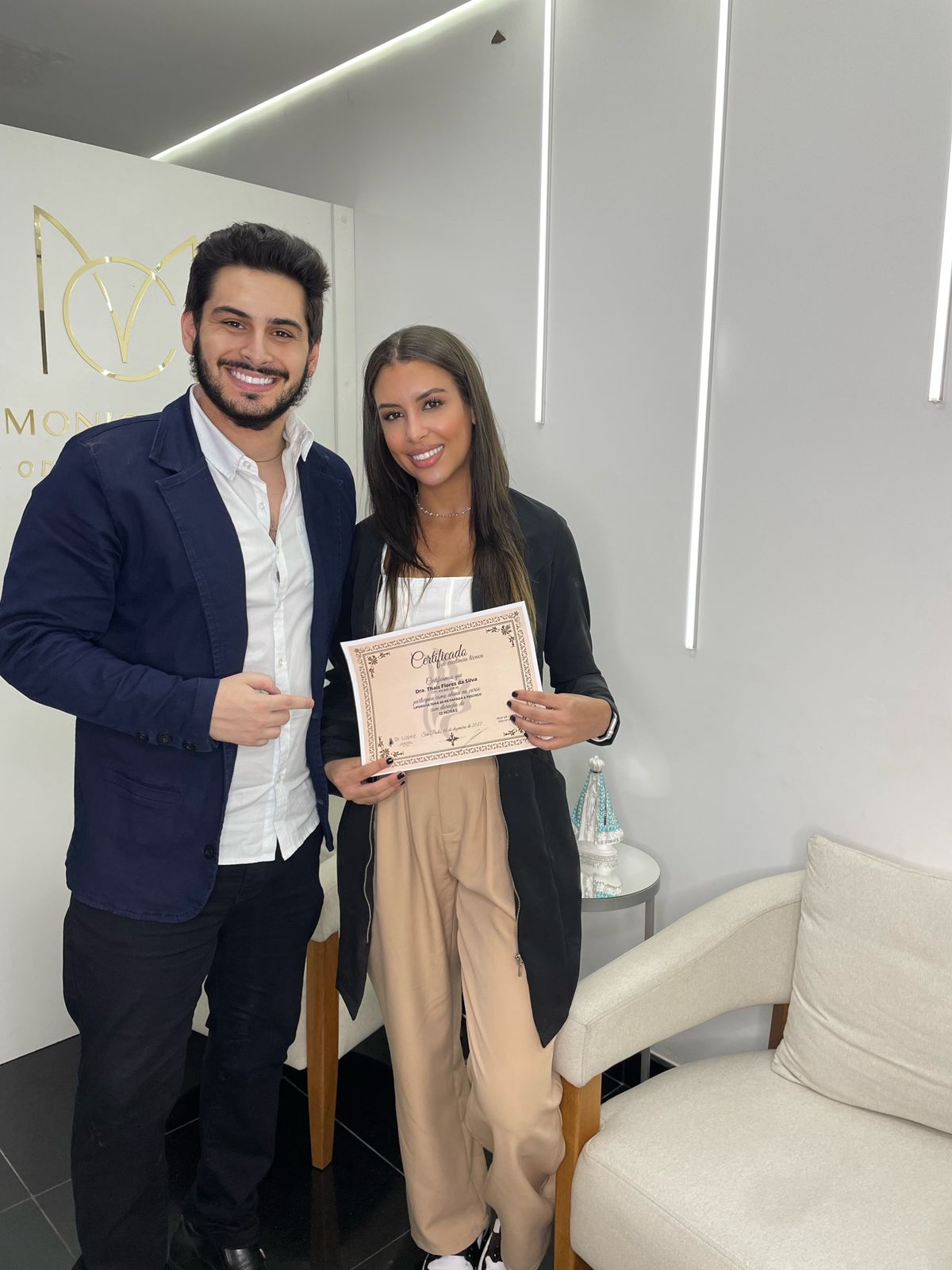 Dr. Lopez ao lado de aluna segurando certificado de lipoescultura de papada e pescoço