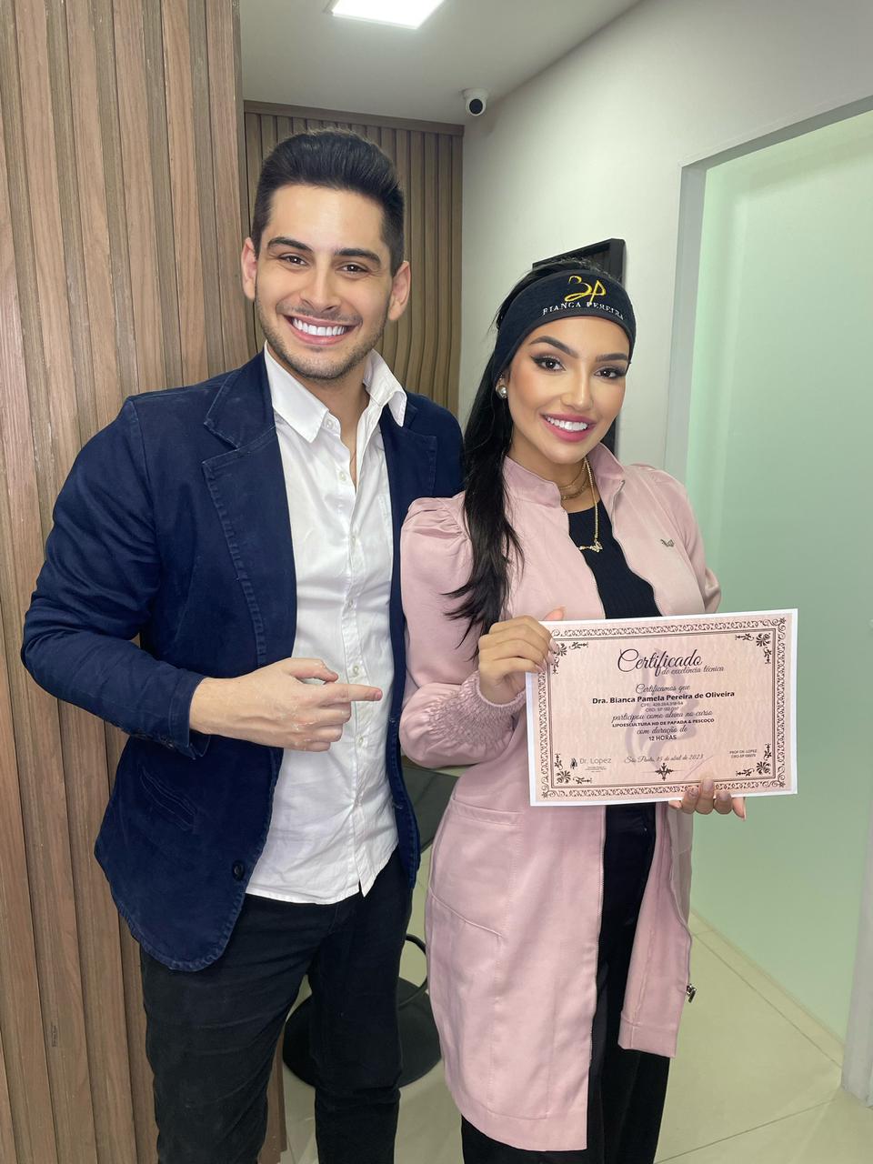 Dr. Lopez ao lado de aluna segurando certificado de lipoescultura de papada e pescoço