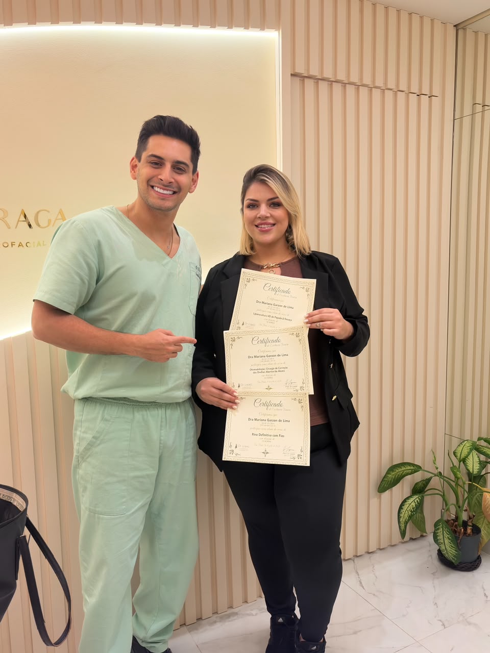 Dr. Lopez ao lado de aluna com certificados da formação presencial