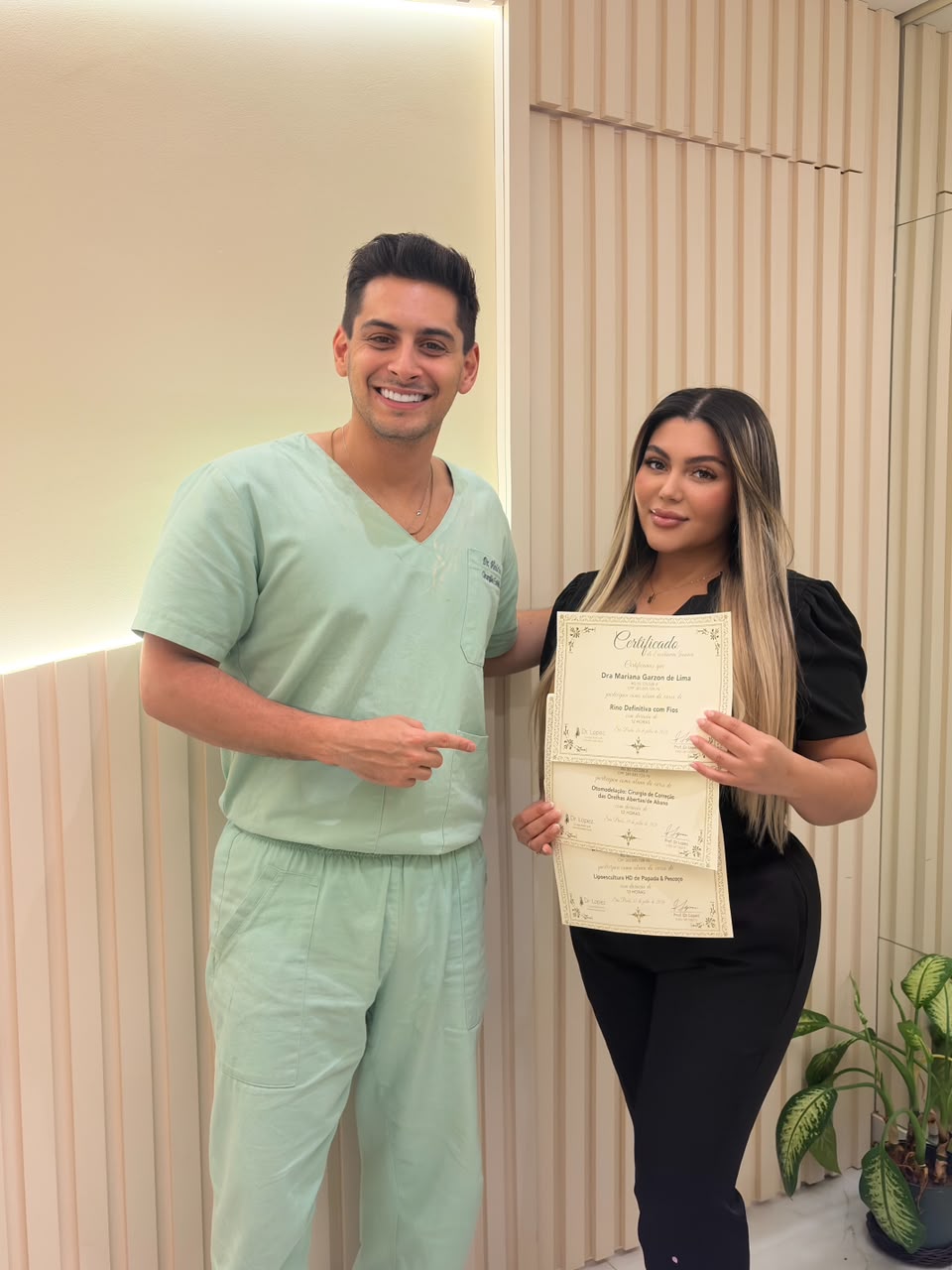 Dr. Lopez ao lado de aluna com certificados da formação presencial